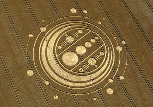 Rain was heavy in Wiltshire County, England, even flooding roads, the first week of August 2009. But at Windmill Hill near Avebury Trusloe, a 350-foot-diameter pattern of circles on rings with complex dumbbells in the center was reported on August 6. Aerial image © 2009 by Frank Laumen, VisibleSigns.de. More information and images: Cropcircleconnector.com.