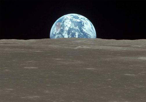 Apollo 11 photograph of wet, blue Earth rising over dry, gray lunar foreground, July 20, 1969.