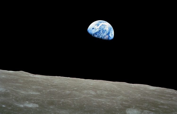 Earth photograph taken by Apollo 8 crewmember Bill Anders on Christmas Eve December 24, 1968, while in orbit around the Moon, showing the Earth rising for the third time before the Apollo 8 crew above the lunar horizon, approximately 780 kilometers from the spacecraft. Width of the photographed area at the lunar horizon is about 175 kilometers. The land visible on Earth cut across by dark shadow is west Africa. The Earth appears to move up and down a little 1) when the orbital distance between the moon and Earth changes; 2) libration, which is slight movement of Earth due to eccentricity of the moon's orbit; 3) rotation of Earth while the moon does not rotate and always has the same face toward Earth. 