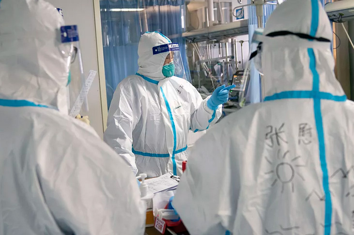 Critical Care Medicine Director Peng Zhiyong (center) with a Wuhan coronavirus patient and medical colleagues at Zhongnan Hospital, Wuhan University, in central China's Hubei Province. Death toll now 82 and cases increasing rapidly toward 3,000. Image by Xiong Qi, Xinhua via Associated Press.